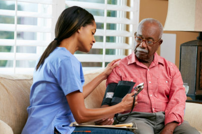 caregiver getting elder man's blood pressure