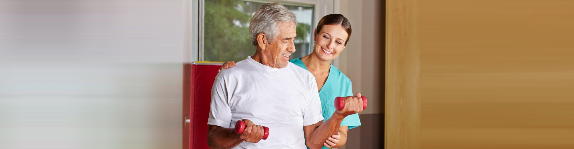 senior man with dumbbells in rehab center with caregiver